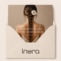 Carte cadeau digitale Inura dans une enveloppe ivoire haut de gamme, illustrée par une femme de dos à la longue natte ornée d’une fleur blanche.