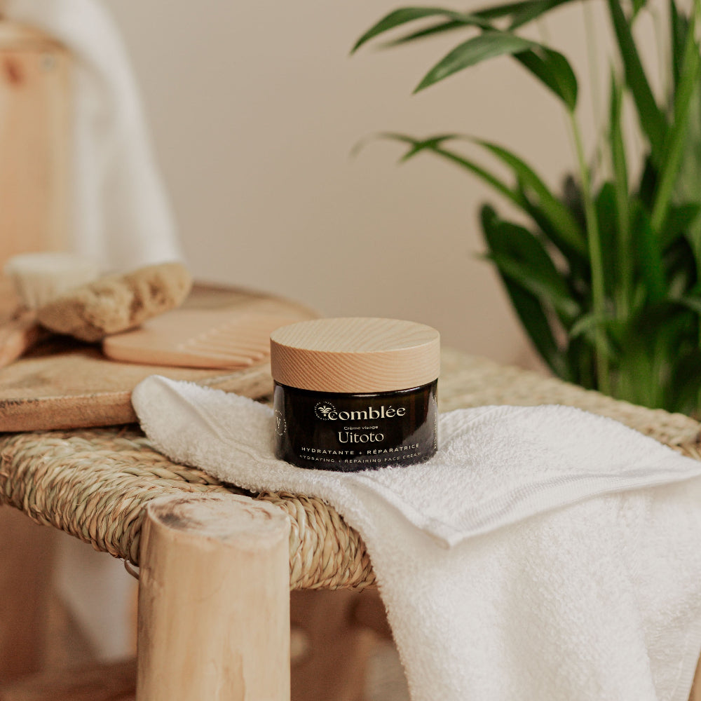 Crème visage Uitoto Comblée avec pot rechargeable, soin hydratant et réparateur présenté dans un décor naturel.