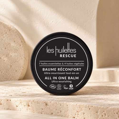 Baume Réconfort Rescue Les Huilettes présenté dans un décor minéral beige et minimaliste
