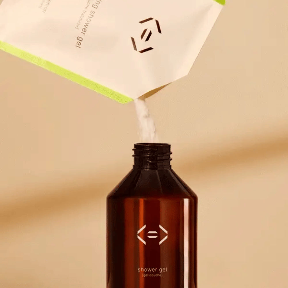 Poudre de gel douche Less is More à diluer avec de l’eau pour obtenir un gel douche rechargeable basilic citron.