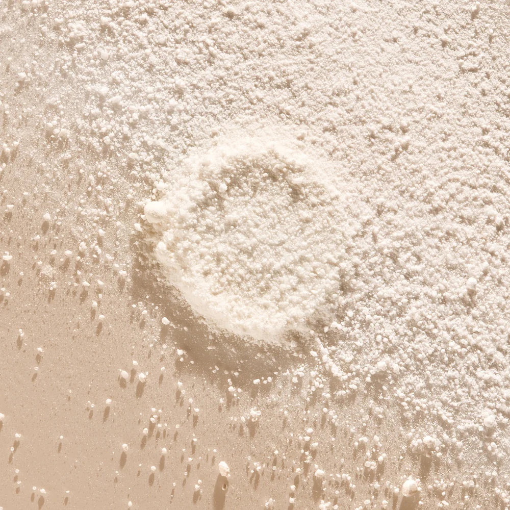 Texture en gros plan de la poudre blanche du Gel lavant mains [néroli + cédrat] de less is more, formule concentrée à diluer avec de l’eau pour obtenir un gel lavant liquide