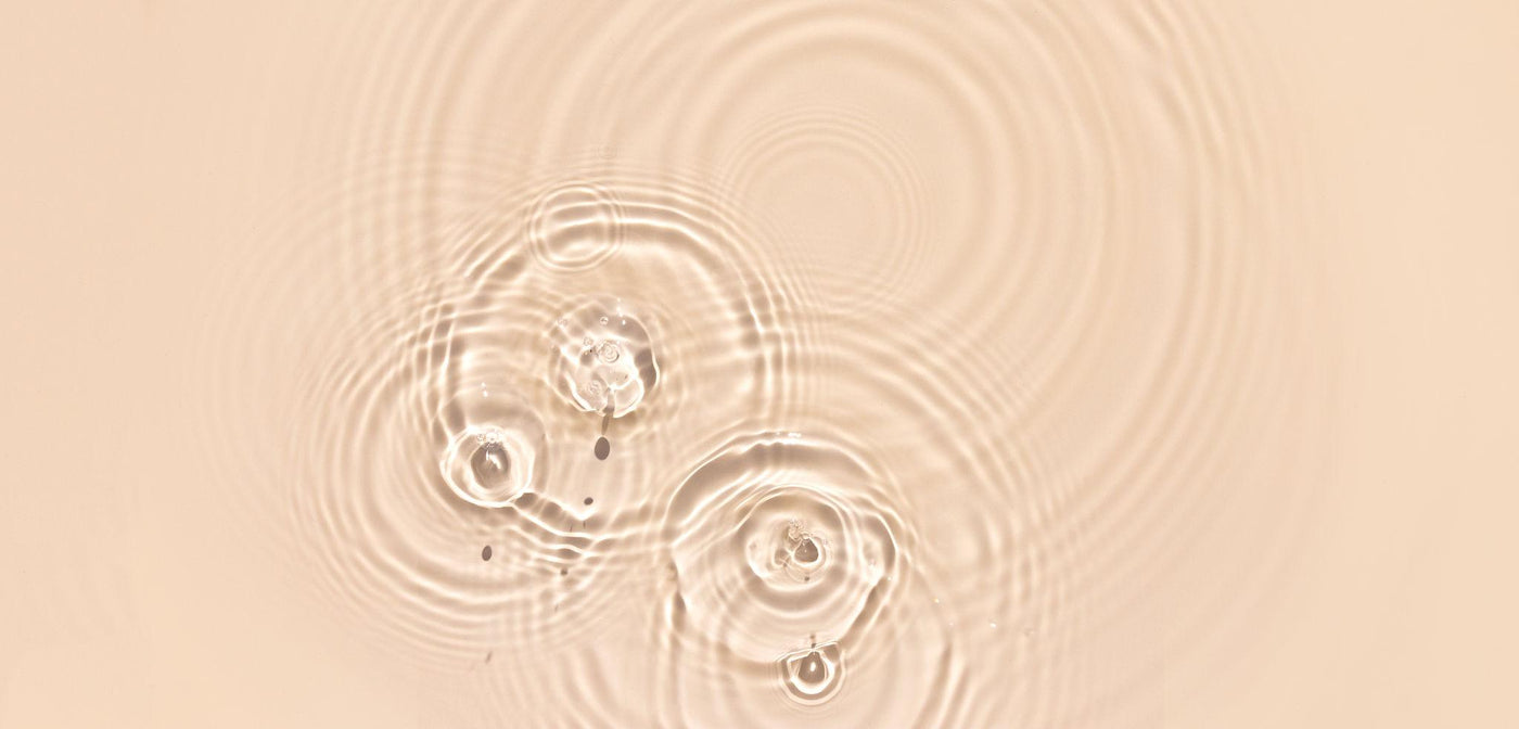 Visuel de la page Nos Exclusions Inura illustrant les perturbateurs endocriniens, avec texture de sérum cosmétique et goutte transparente sur fond clair, dans une esthétique clean beauty minimaliste.
