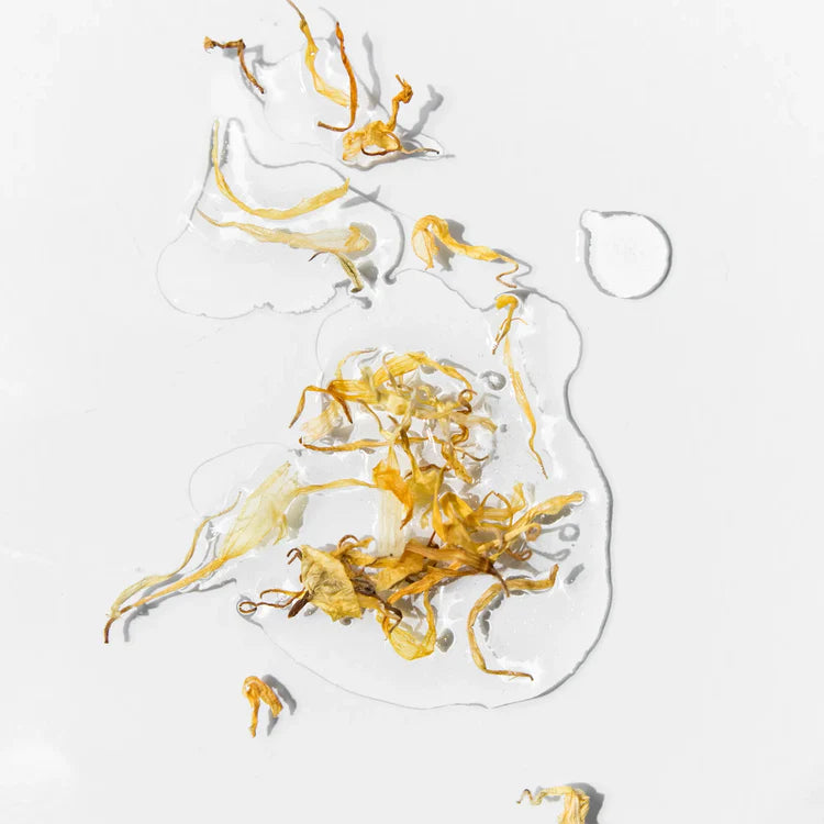 Texture de l’huile corps et cheveux P.Lab Beauty avec pétales de calendula et fini nacré doré.