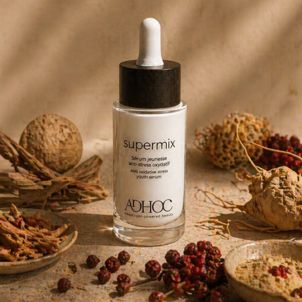 sérum adaptogène Supermix Adhoc entouré de racines et poudres végétales, illustrant une formulation clean beauty riche en actifs naturels pour la peau