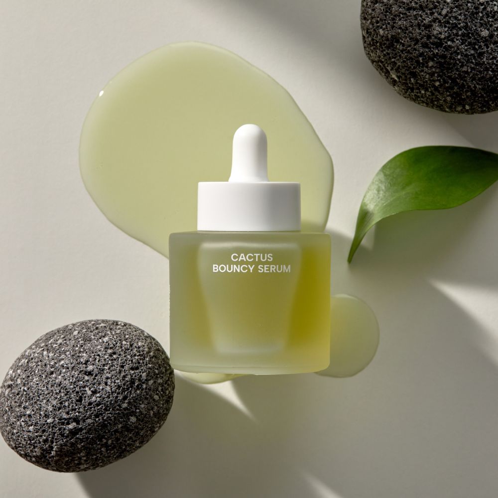 Sérum visage hydratant Cactus Bouncy Serum Whamisa au figuier de barbarie, présenté dans un décor minéral.