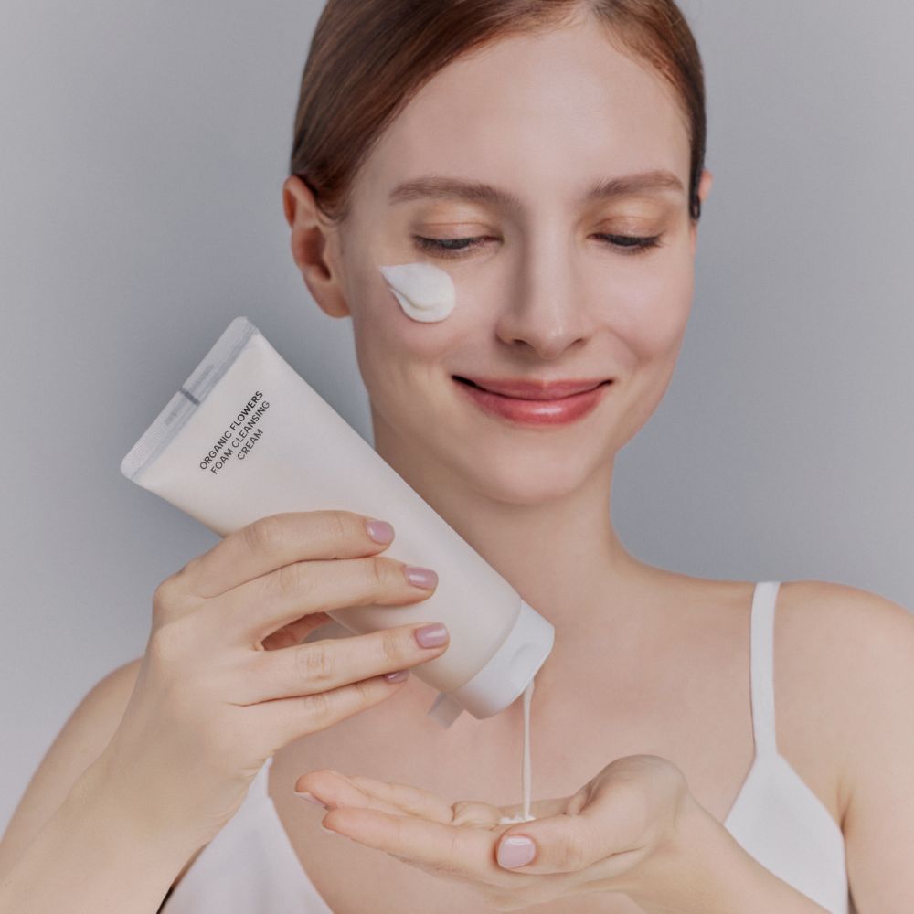 Application de la crème nettoyante moussante Whamisa, nettoyant visage doux pour éliminer les impuretés.