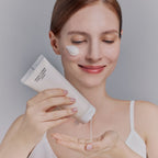 Application de la crème nettoyante moussante Whamisa, nettoyant visage doux pour éliminer les impuretés.