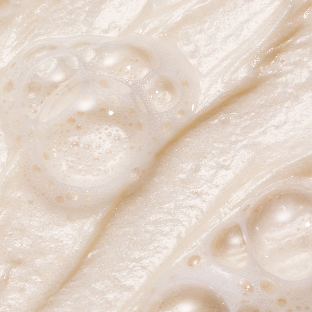 Texture mousse douce de la crème nettoyante Whamisa aux fleurs fermentées, soin nettoyant pour une peau fraîche et confortable.